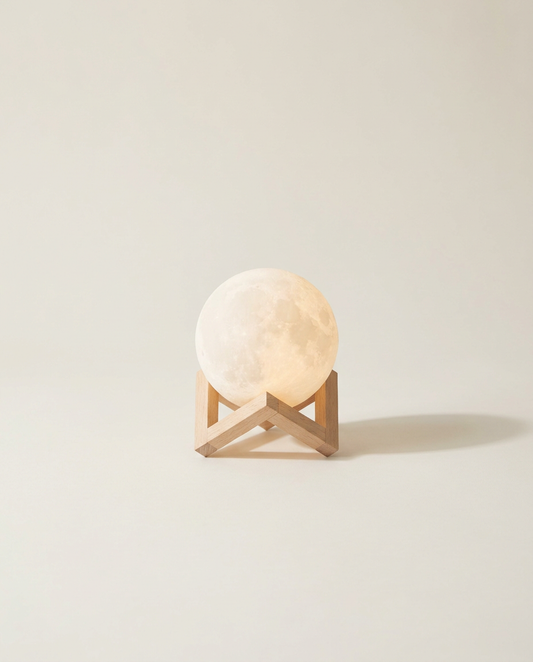The Moon — Table Light, moon lamp on a light-wood stand against a bone backdrop